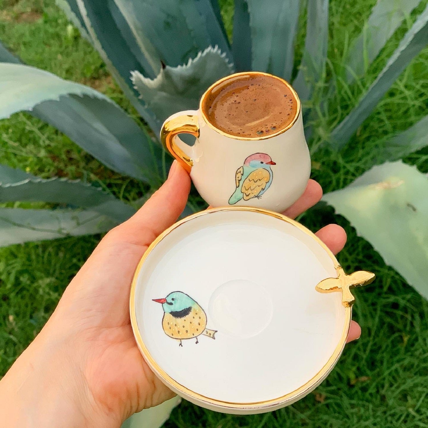 Coffee cup with saucer, white ceramic with gold handle, blue bird motif, gold-edged plate