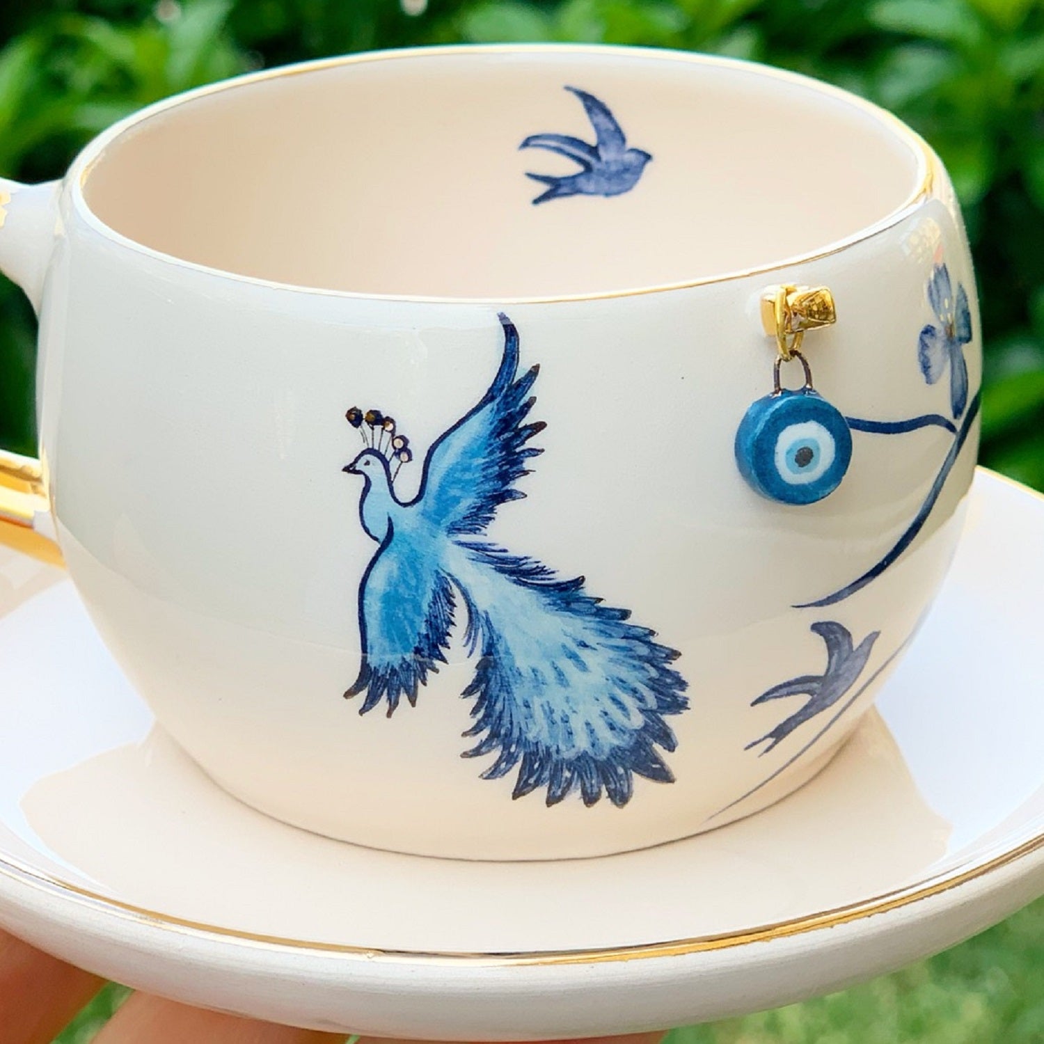 Porcelain mug with blue phoenix bird design and blue eye charm on the side