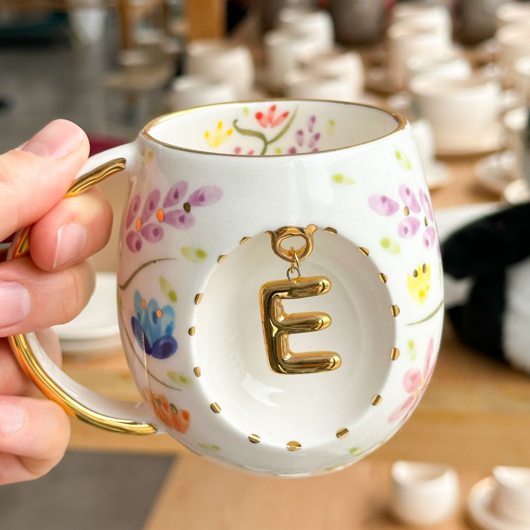Porcelain letter mug with gold handle and gold letter E, spring floral pattern