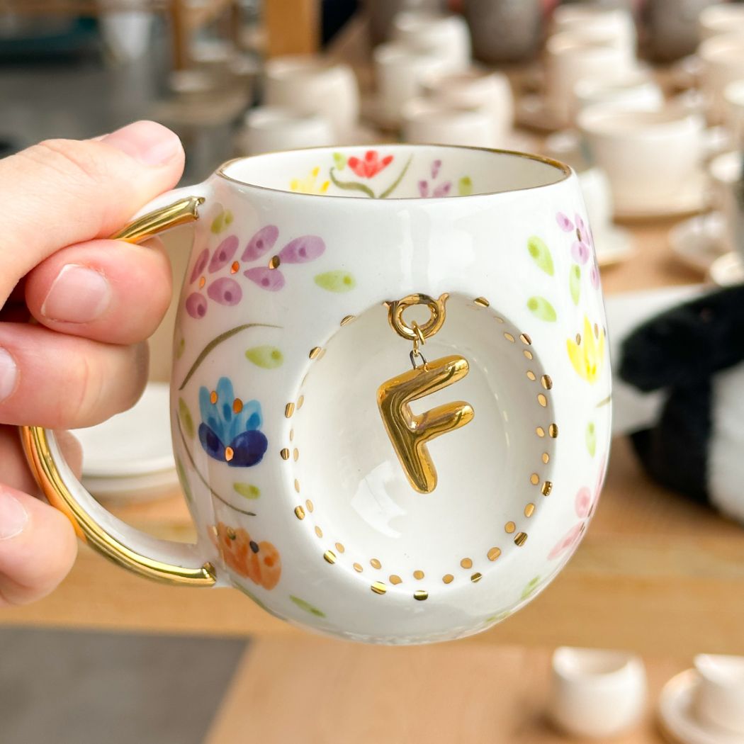 Porcelain letter mug with gold handle and gold letter F, spring floral pattern