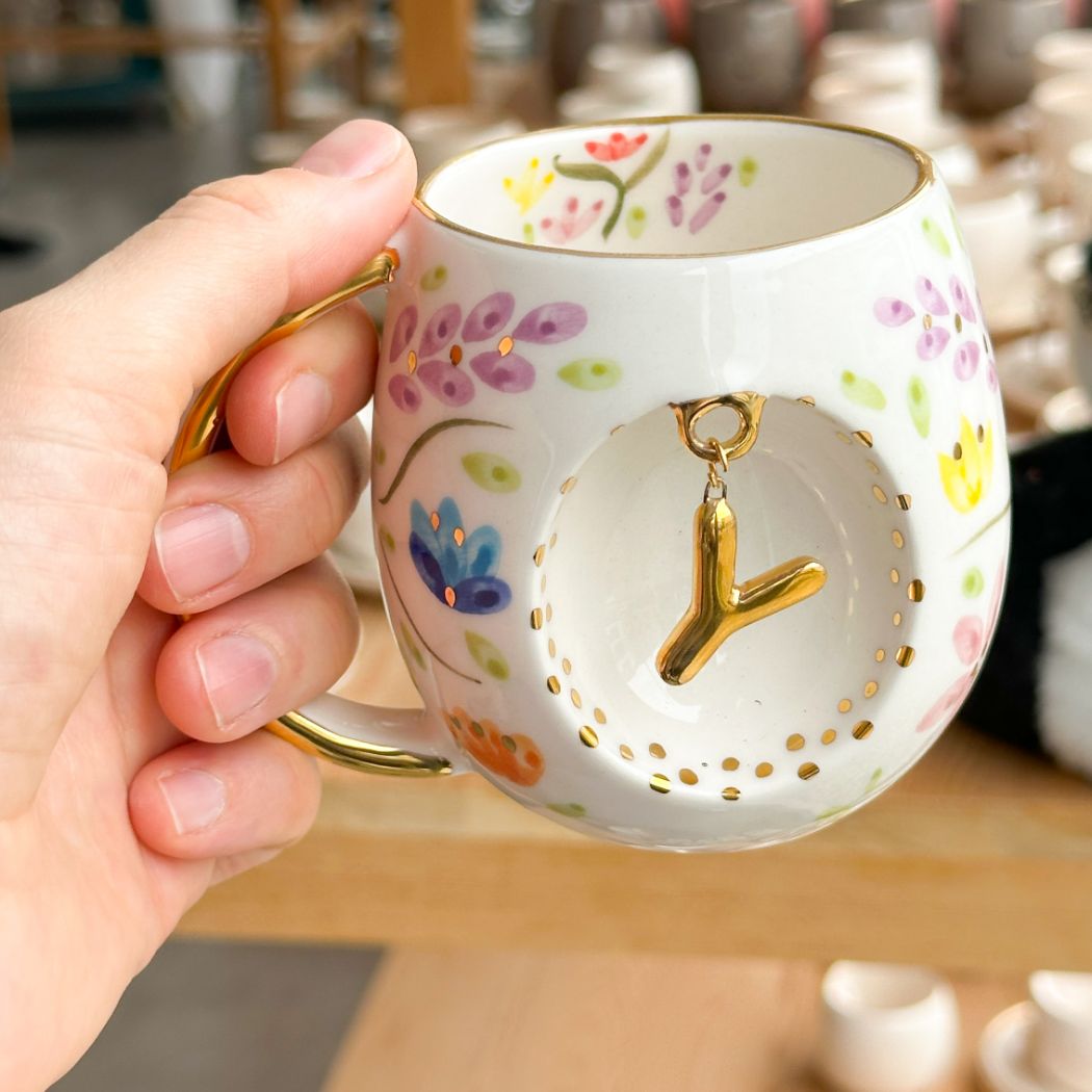 Porcelain letter mug with gold handle and spring floral design, featuring gold letter charm