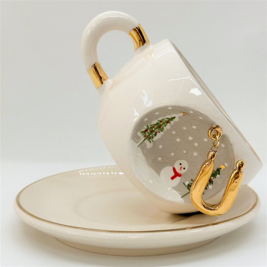 Porcelain tea cup and saucer, gold handle, letter S charm with snowman and trees