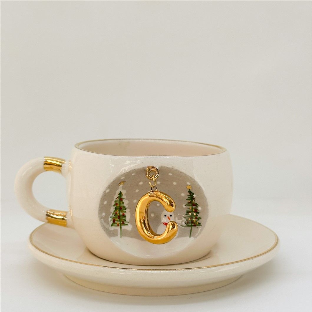 Porcelain tea cup and saucer, gold handle, letter C charm with winter tree scene