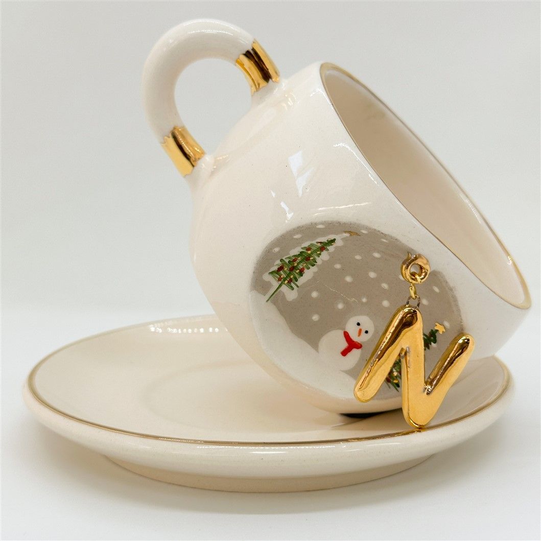 Porcelain tea cup and saucer with gold handle, hanging winter letter charm, snowman detail