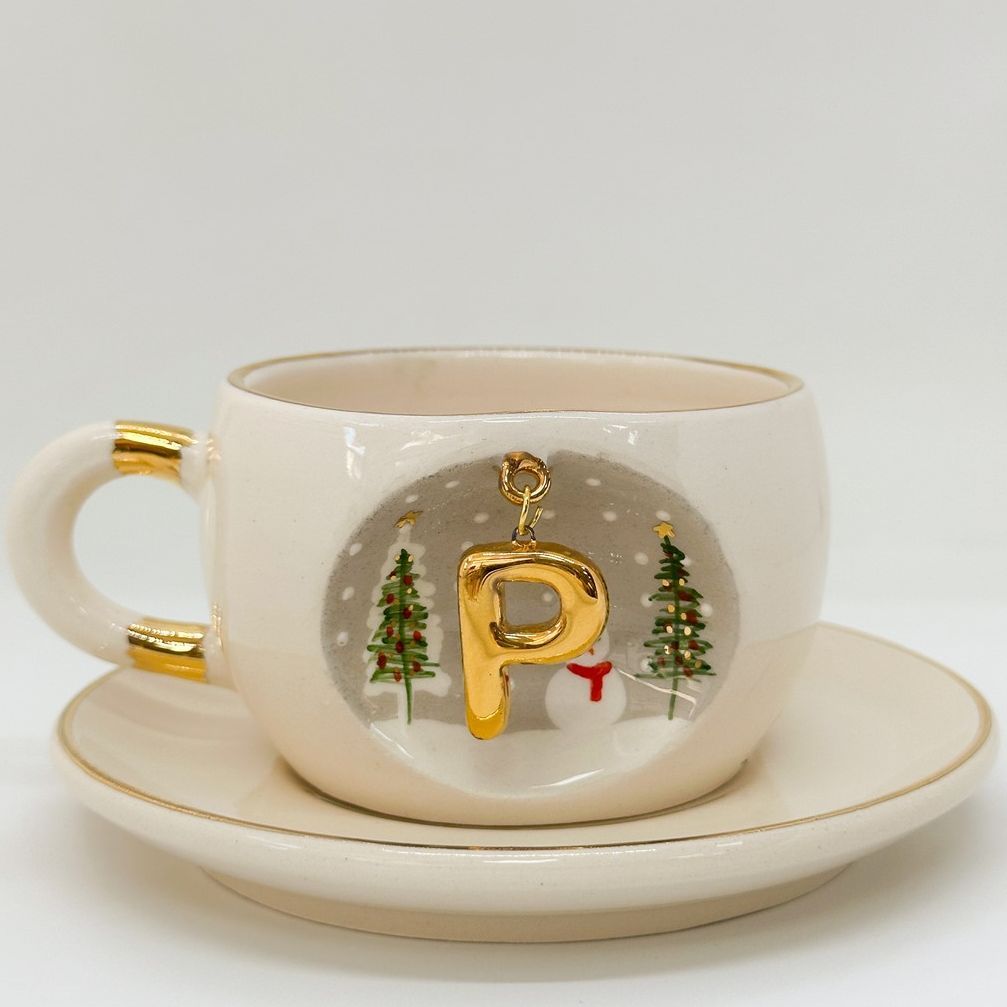 Porcelain tea cup and saucer with gold handle, hanging winter letter charm, festive snowman detail