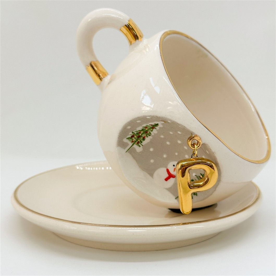 Porcelain tea cup and saucer with gold handle, hanging winter letter charm, scarfed snowman detail