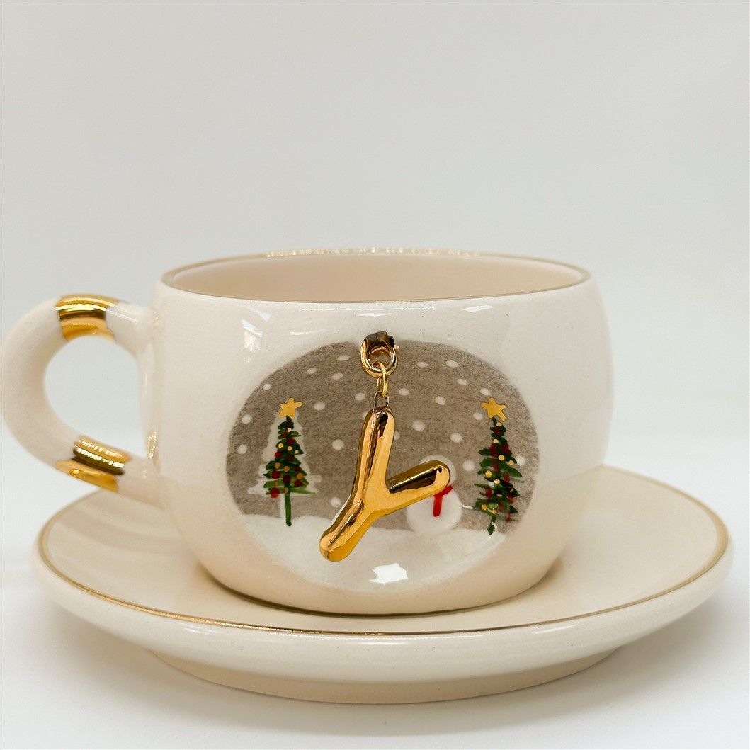 Porcelain tea cup and saucer, white with gold rim and handle; winter Y letter motif