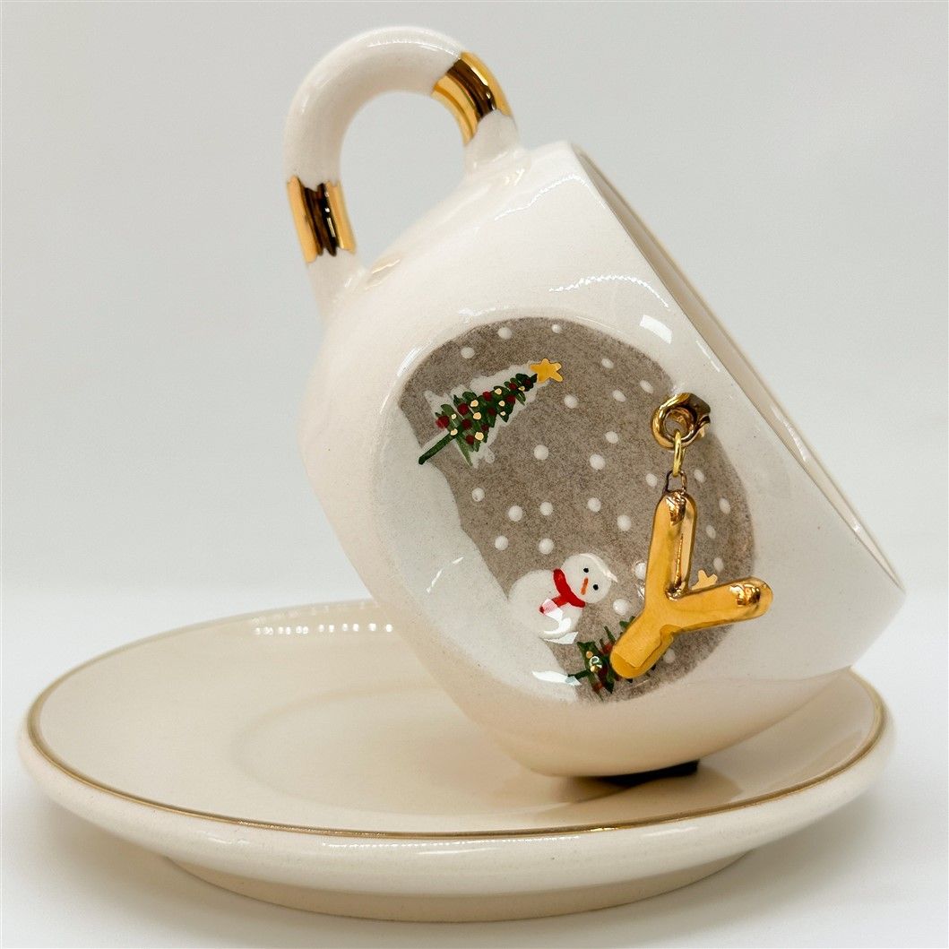 Porcelain tea cup and saucer, white with gold rim and handle; winter Z letter motif