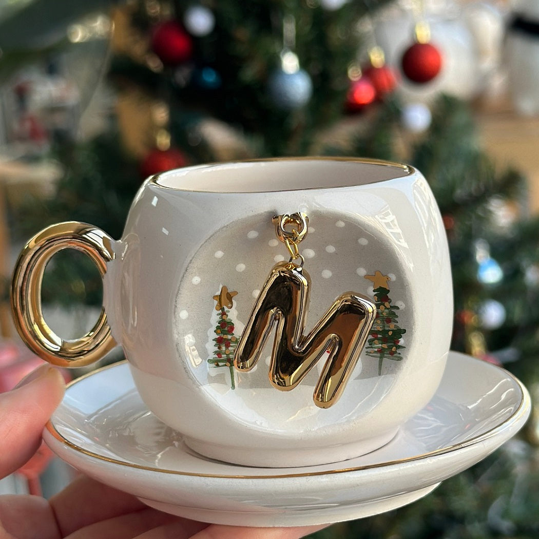Porcelain coffee cup and saucer, off-white with gold handle and letter 'W' with trees