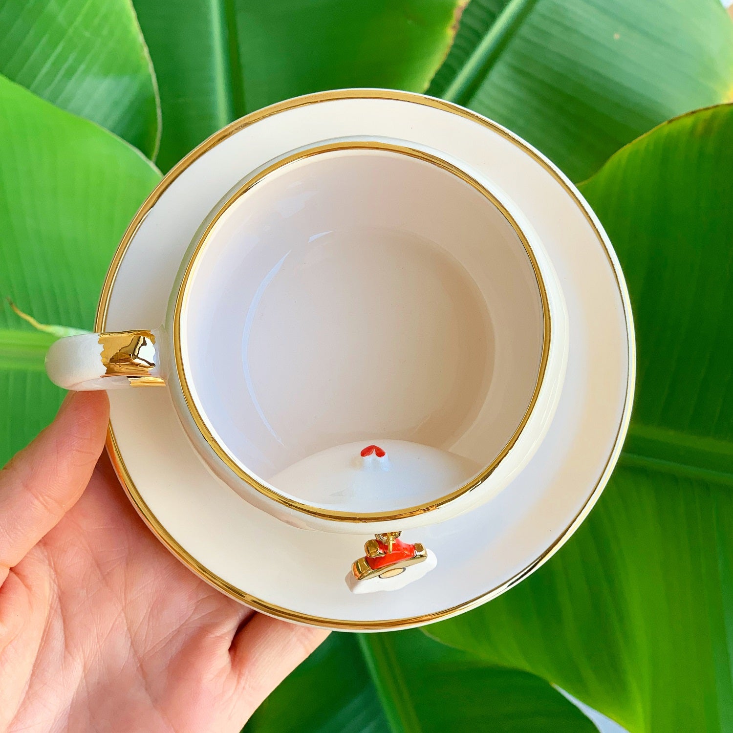 White tea mug with gold rim and Father Christmas charm on inside edge, top view