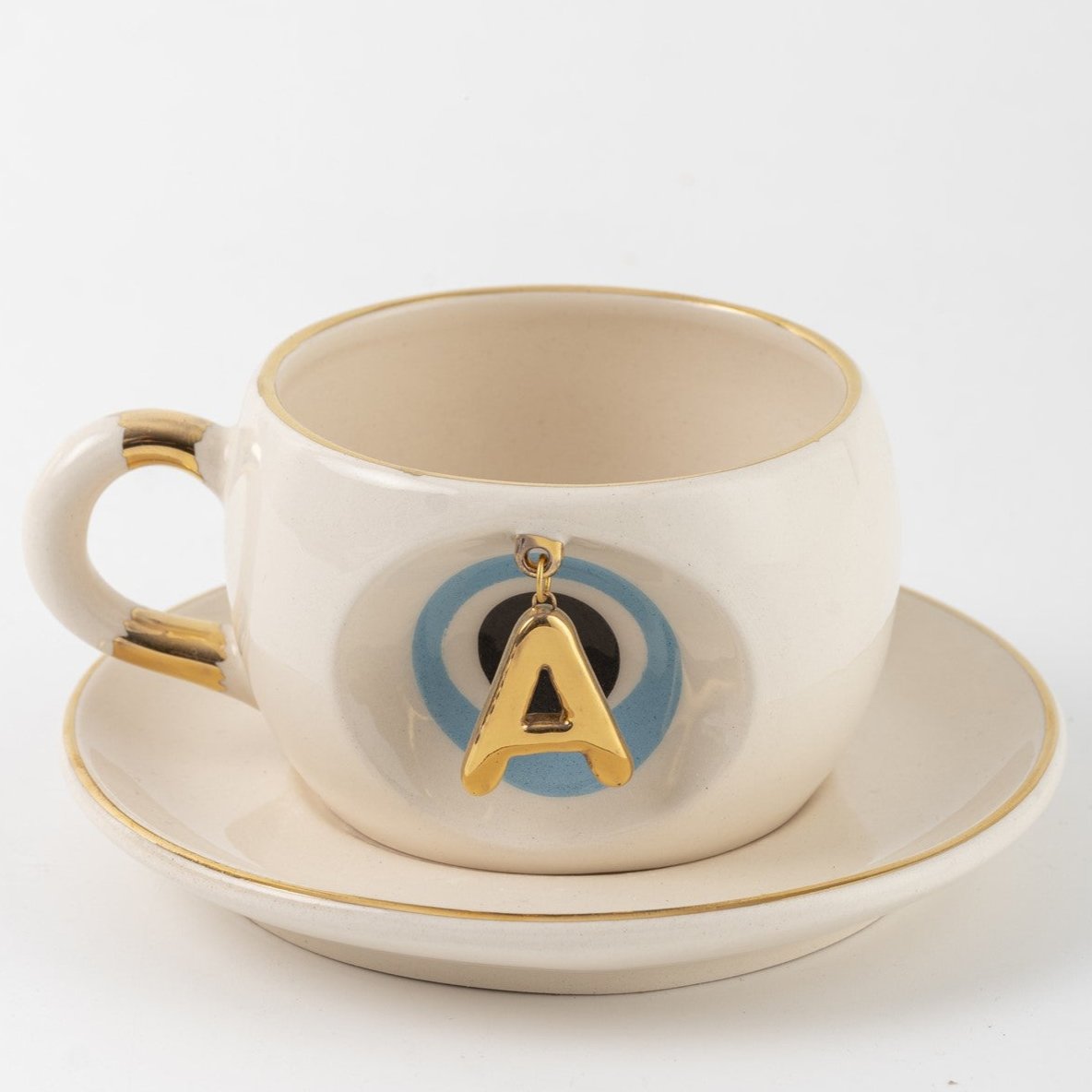 Tea mug with saucer, white ceramic, gold trim, blue medallion letter A