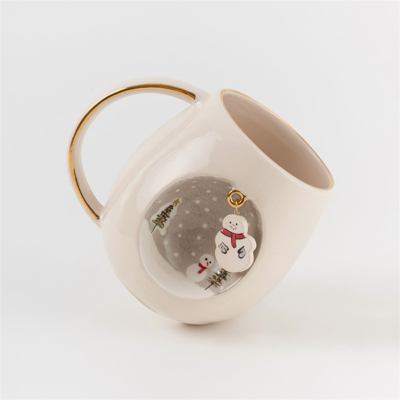 White ceramic mug with gold handle, snowman and pine trees visible on side panel