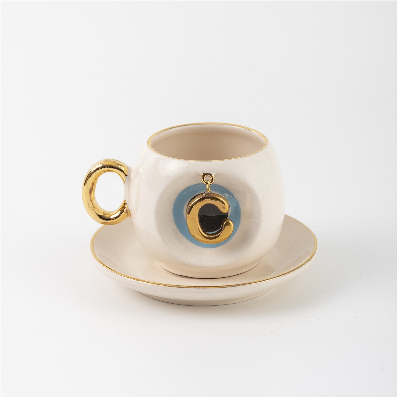 Ceramic Turkish coffee cup and saucer with gold handle, blue letter C charm