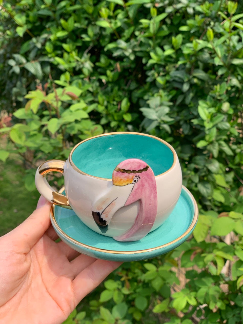 Nile green tea mug and saucer with flamingo artwork and gold-tone handle