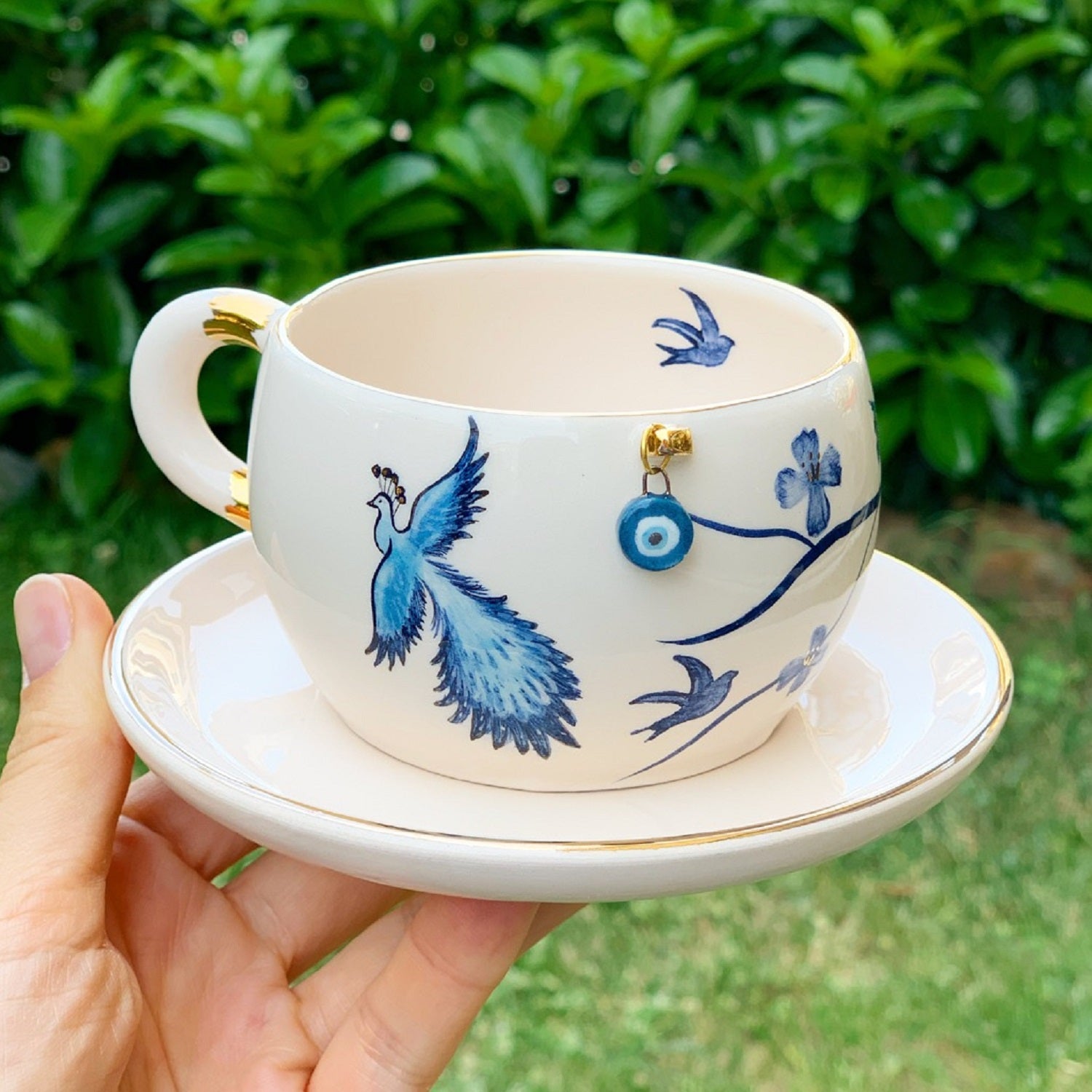 Porcelain mug and saucer set with blue bird and eye motif