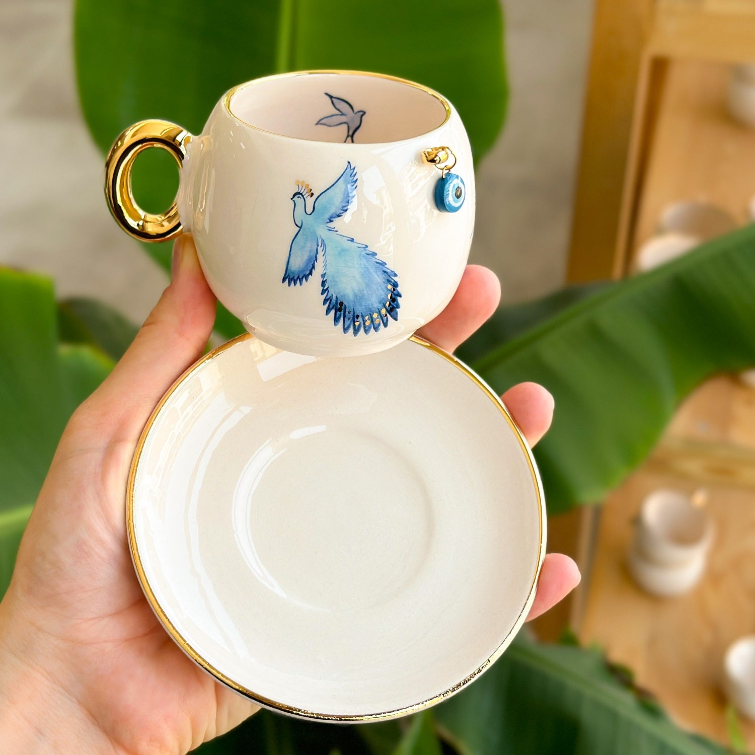 Coffee cup and saucer, white with blue bird design and gold rim, gold handle