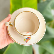 Cream ceramic mug top view with gold rim; hot air balloon graphic on inner base