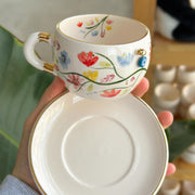 Tea cup and saucer with colorful spring floral pattern and gold rim