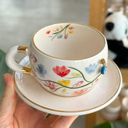 Tea cup with floral garden motif, gold handle ring and blue eye charm