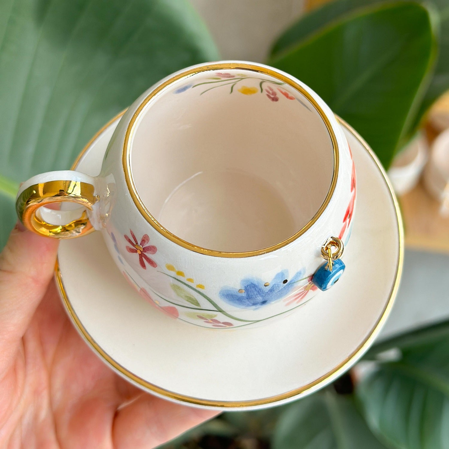 Porcelain coffee cup and saucer set with gold rim, blue eye charm and flowers
