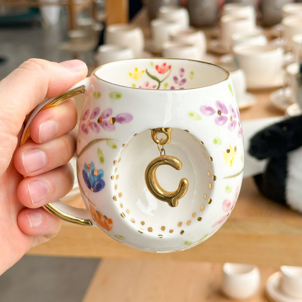 Porcelain letter mug with gold handle and spring floral design, with gold letter charm, 230 ml