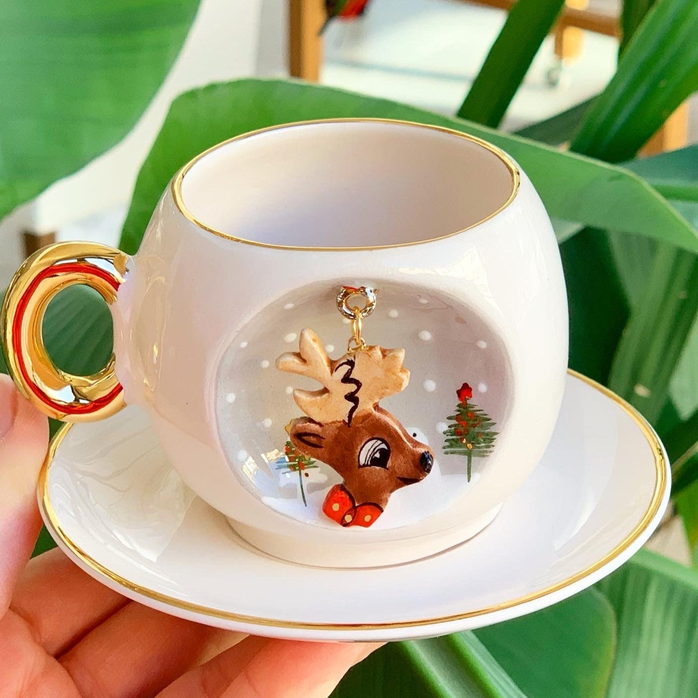 White deer coffee cup and saucer with gold rim and handle