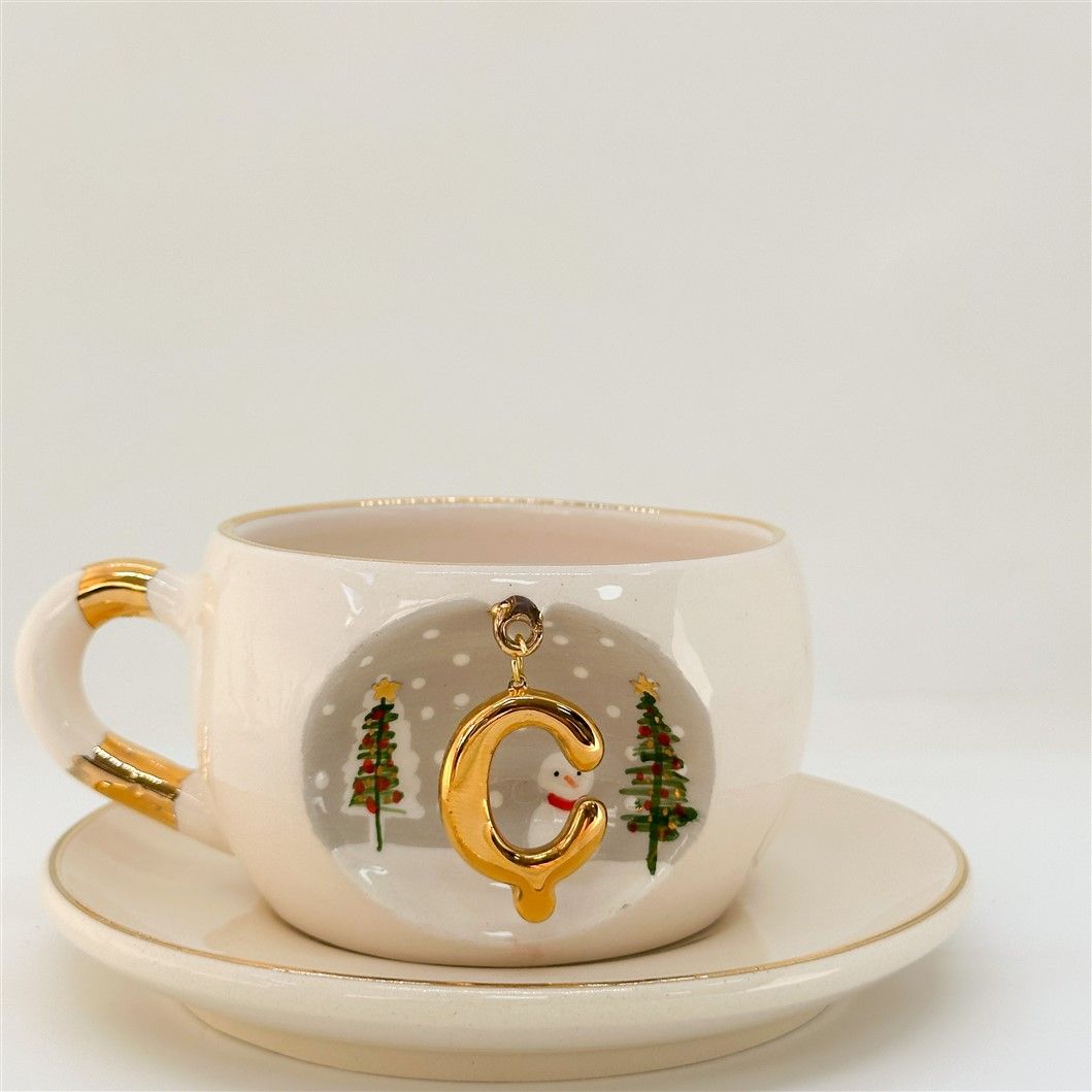 Porcelain tea cup and saucer, white with gold rim and handle; winter C letter motif