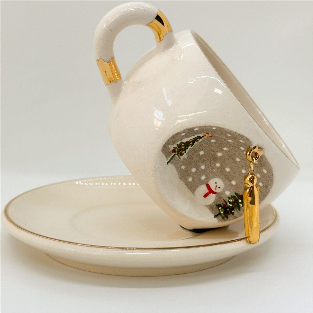 Porcelain tea cup and saucer, white with gold rim and handle; winter I letter design