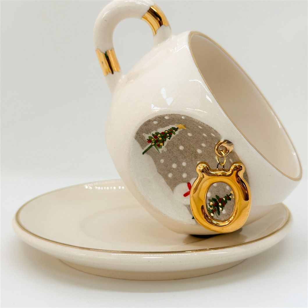 Porcelain tea cup and saucer, gold handle, letter S charm with winter trees