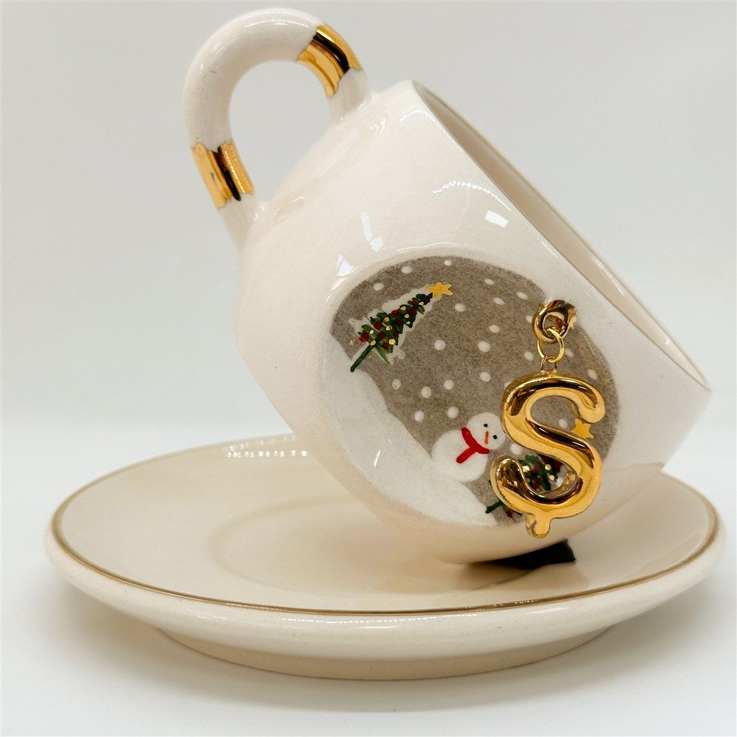Porcelain tea cup and saucer, gold handle, letter S charm and snowman scene