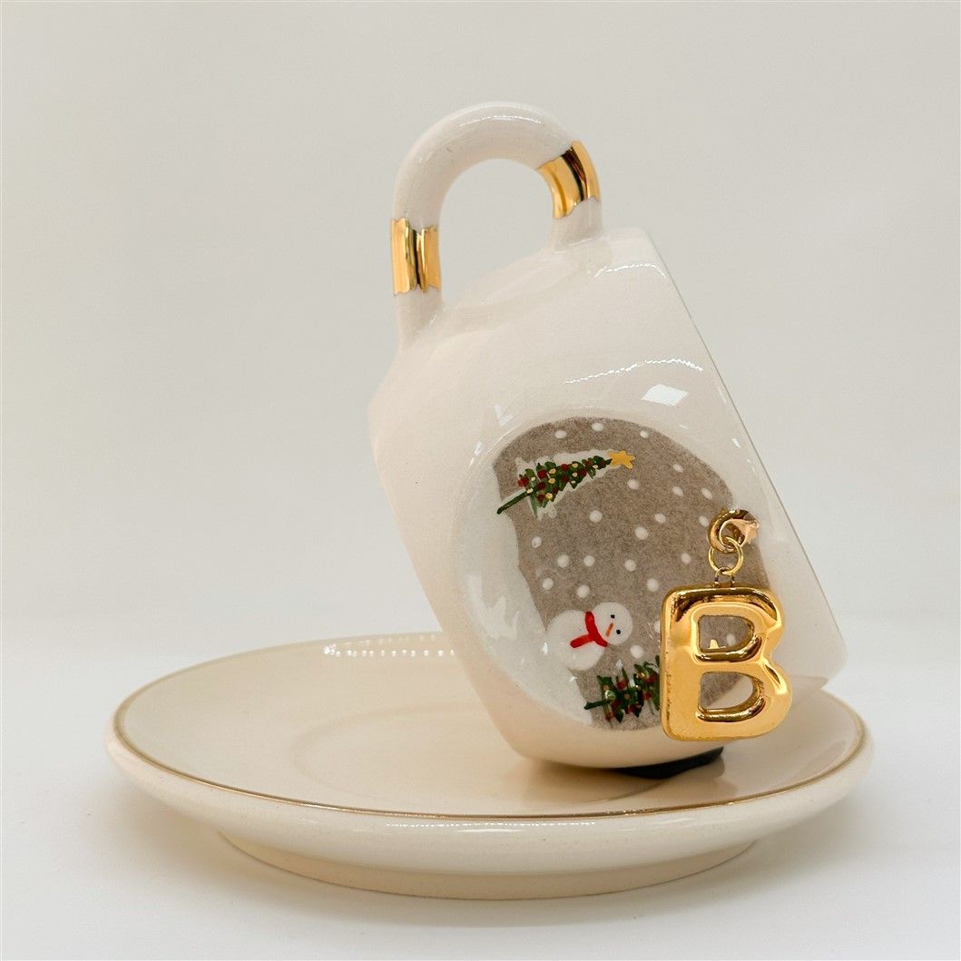 Porcelain tea cup and saucer, gold handle, letter B charm with snowman and trees