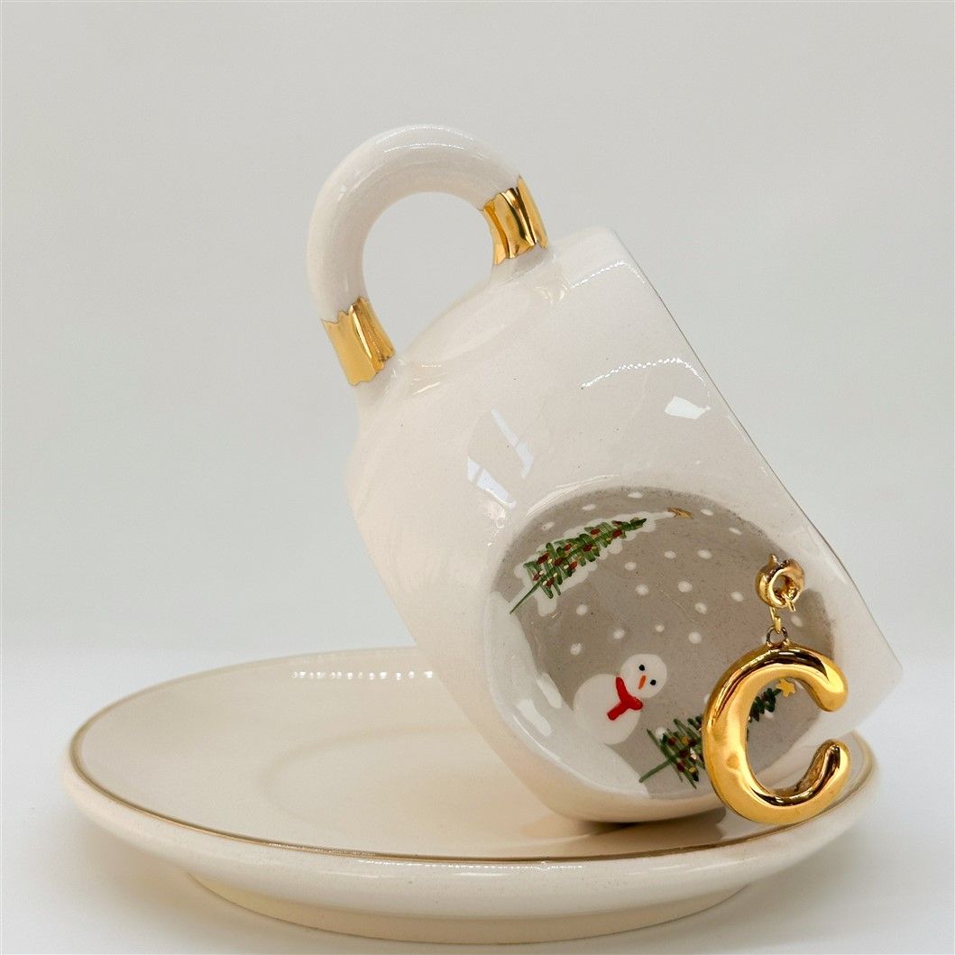 Porcelain tea cup with C letter gold charm, winter trees and snowman graphic, 160 ml