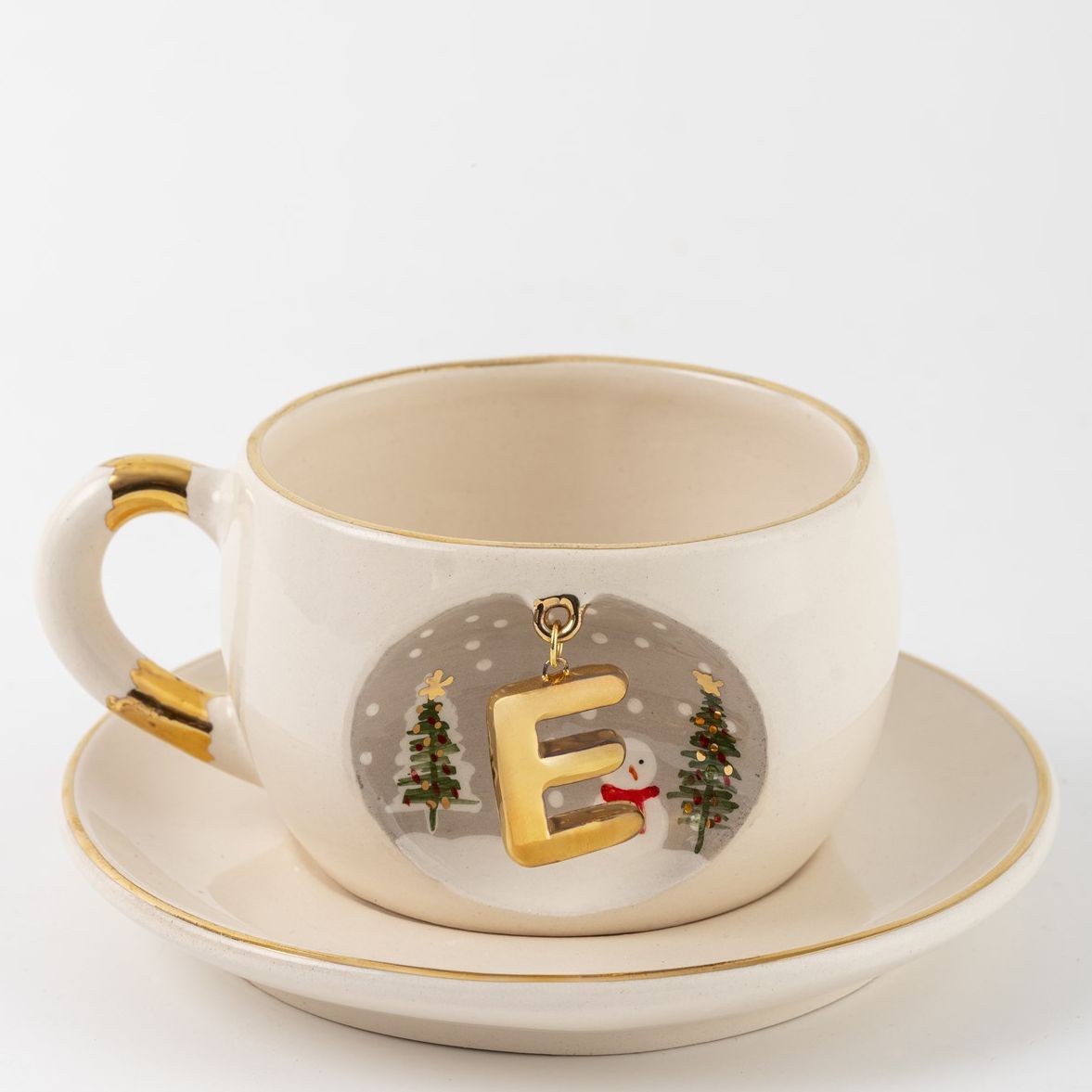 Porcelain tea cup on saucer with E letter gold charm, winter trees and snowman