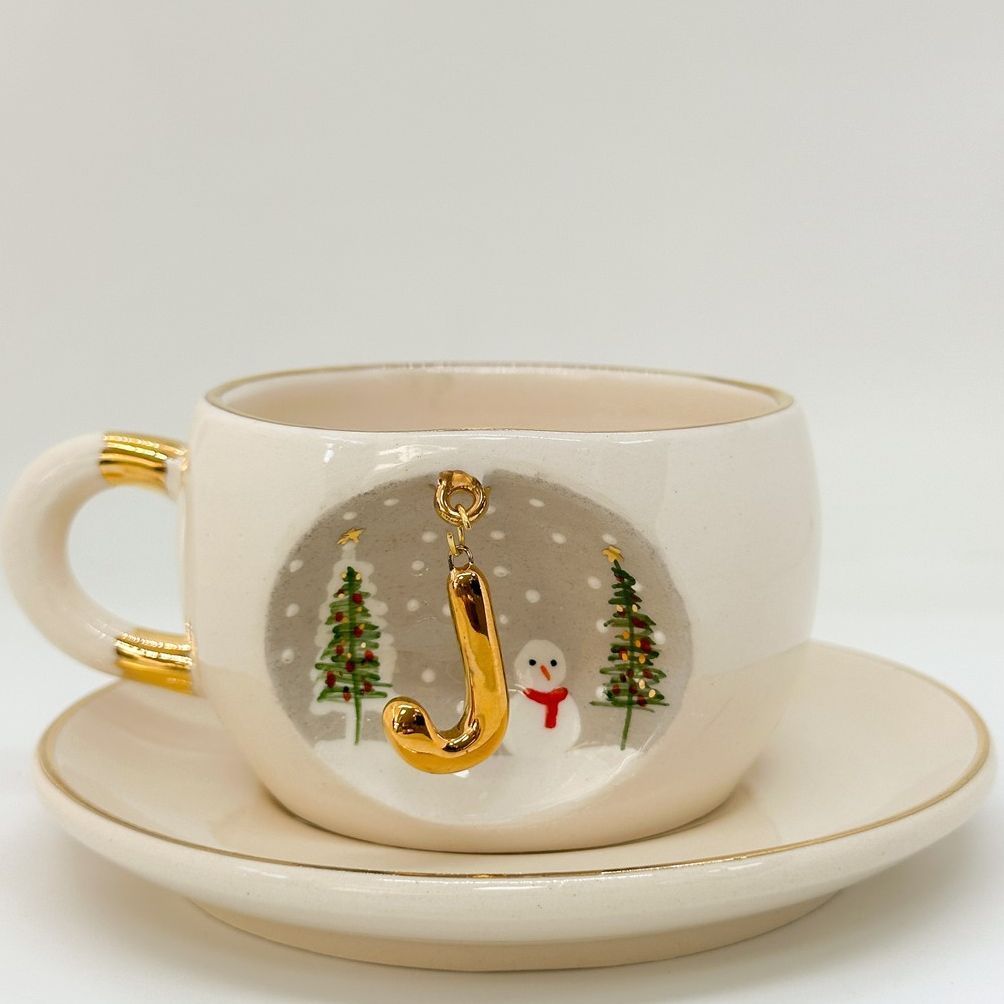 Porcelain tea cup with saucer, gold handle, winter letter charm with Christmas trees and snowman
