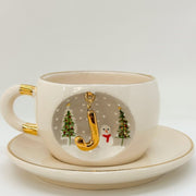 Porcelain tea cup with saucer, gold handle, winter letter charm with Christmas trees and snowman