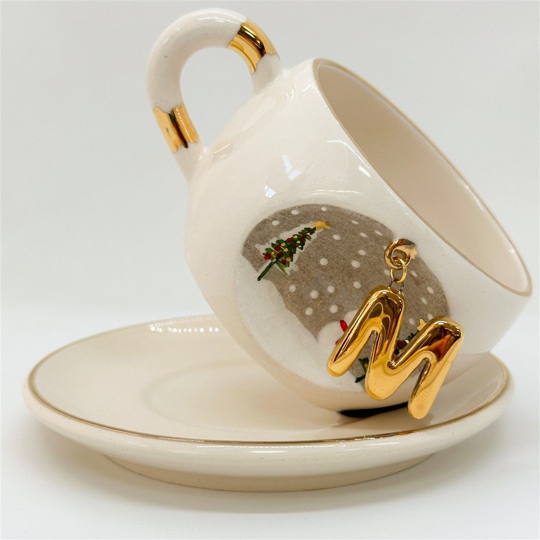Porcelain tea cup with saucer, gold handle accents, winter letter charm and snowman with trees