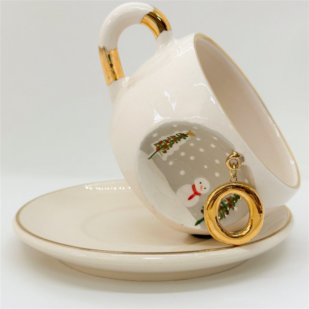 Porcelain tea cup and saucer with gold handle, hanging winter letter charm, snowman and trees