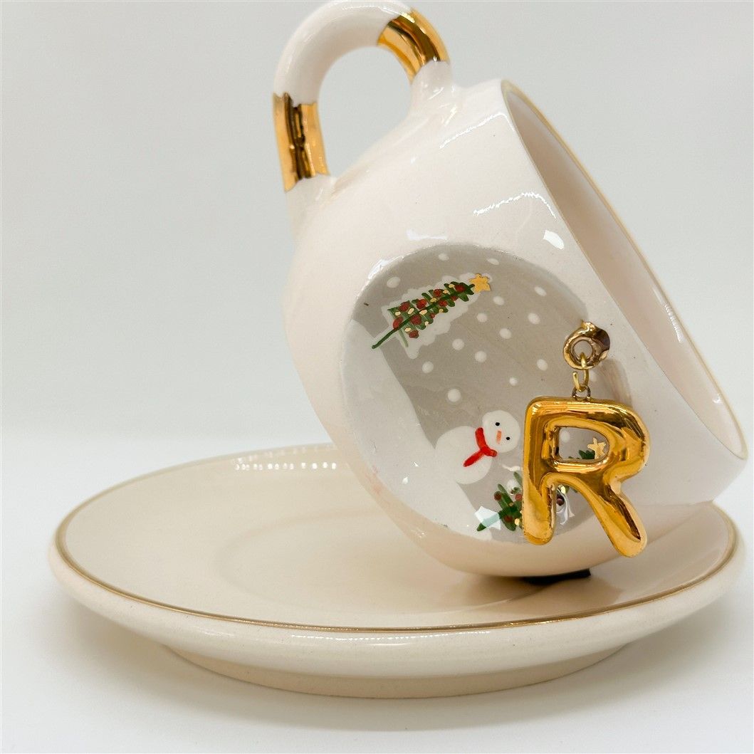 Porcelain tea cup and saucer with gold handle, hanging winter letter charm, snowman and tree decals