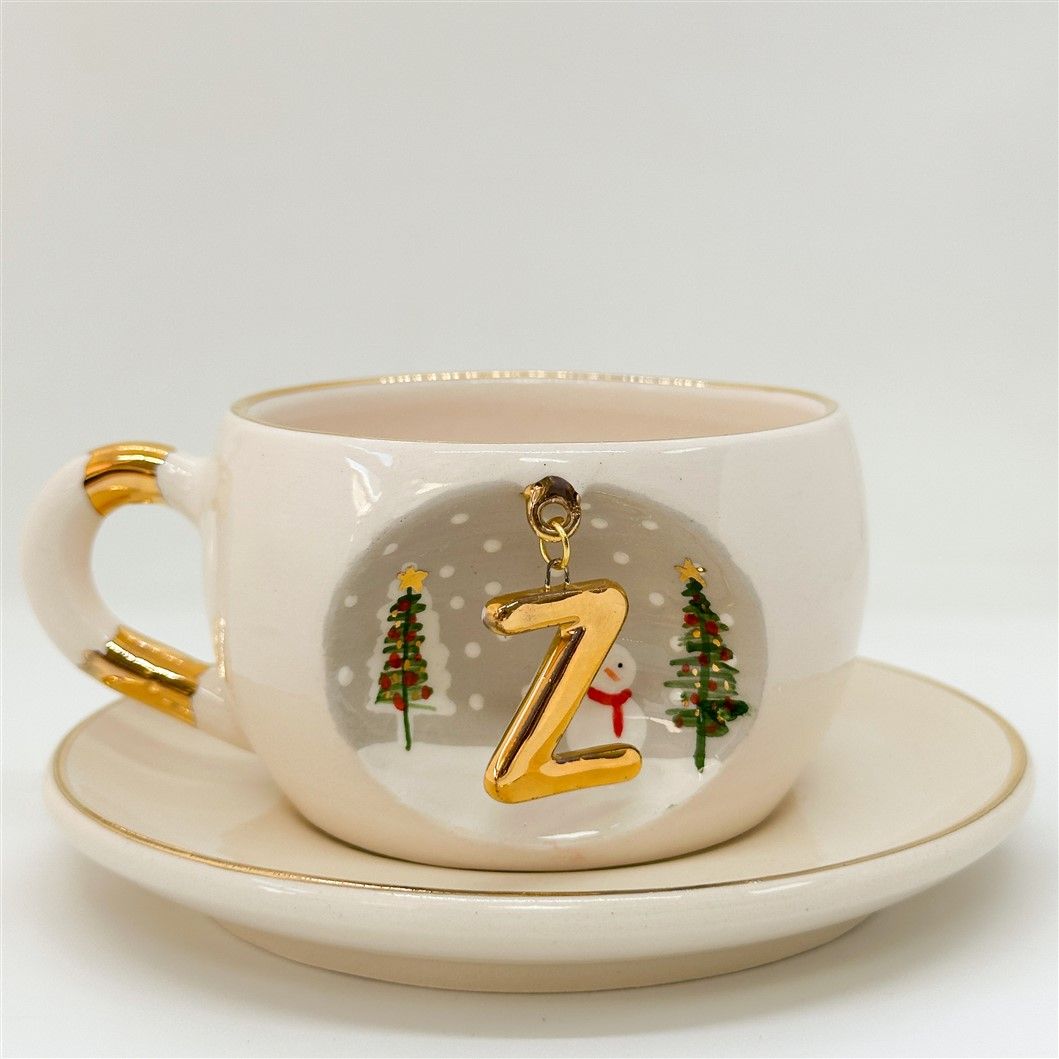Porcelain tea cup and saucer, white with gold rim and handle; winter Z letter design