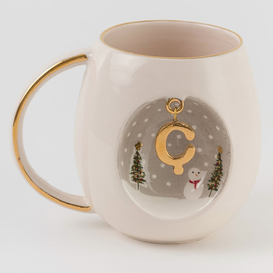 Porcelain mug with gold-tone C letter charm and winter village graphic on front
