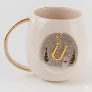 White porcelain mug with gold rim and handle, winter scene with letter J charm