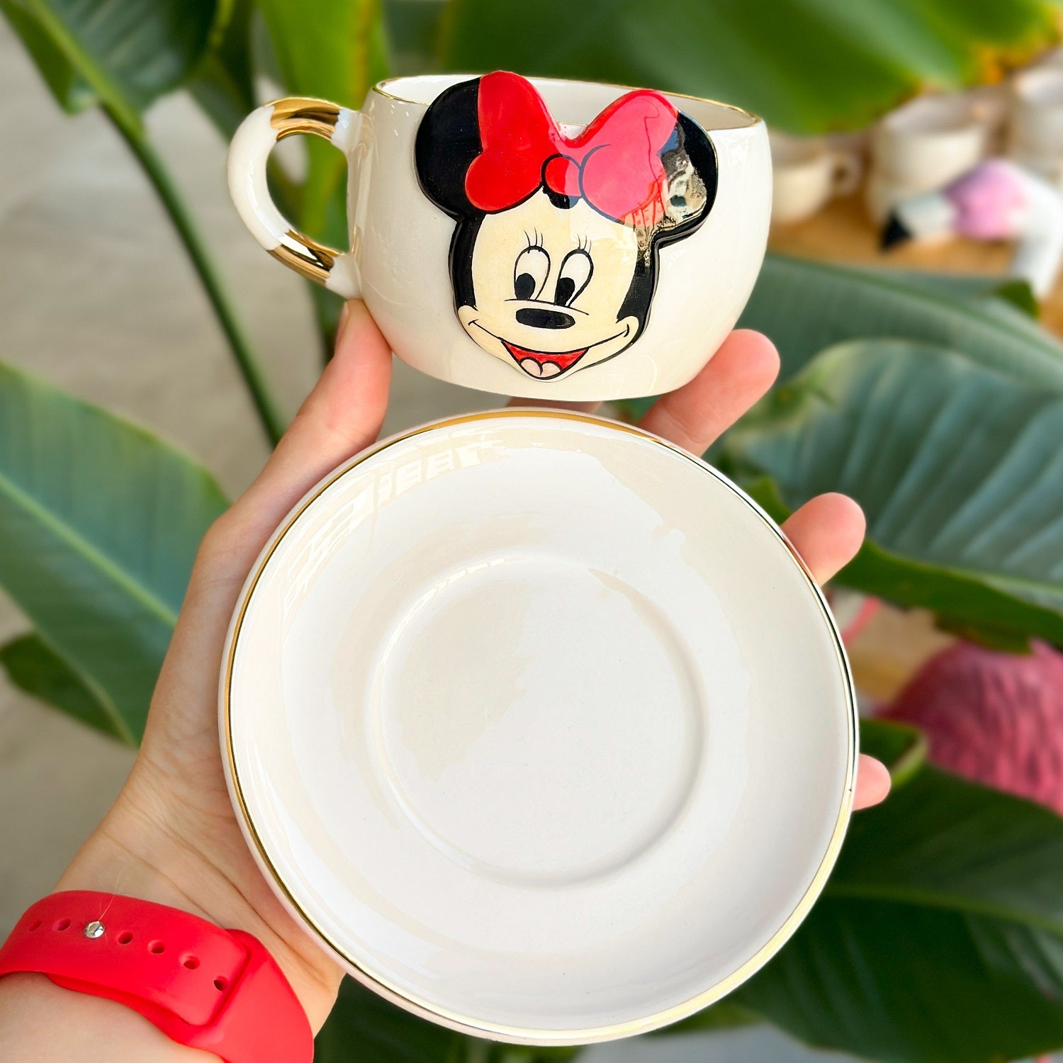 White ceramic tea mug underside with Minnie Mouse graphic and gold rim