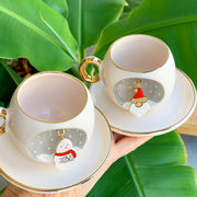 Two ceramic coffee cups and saucers with gold handles, Father Christmas and snowman decals