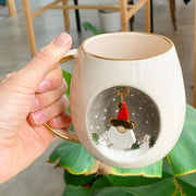 White ceramic mug with gold handle, Father Christmas ornament design on front
