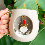 White ceramic mug with gold handle, Father Christmas graphic centered on front