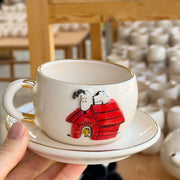 Ceramic Snoopy tea mug and saucer set, white with Snoopy in red-striped doghouse