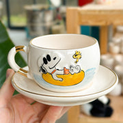 Ceramic Snoopy tea mug and saucer set, white with yellow dog and blue water scene