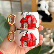 Ceramic coffee cup, cream with red Snoopy house and gold handle