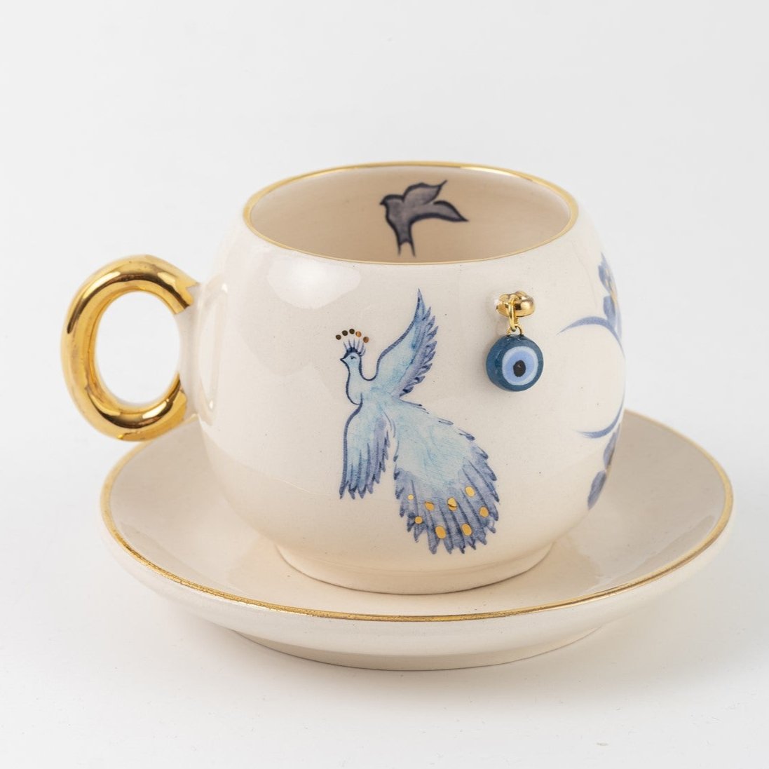 Coffee cup and saucer set, white with blue bird and black phoenix silhouette, gold trim