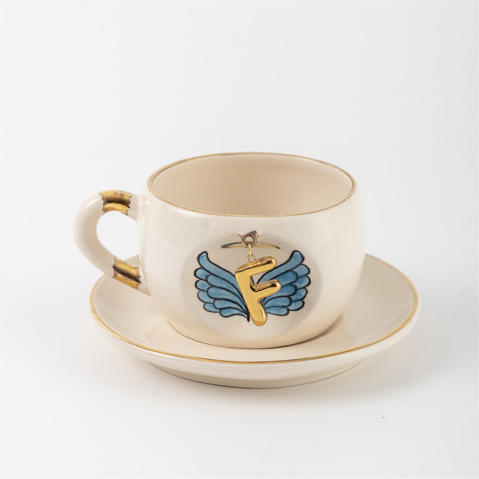 Ceramic angel-wing letter mug with blue wings and gold F, on matching saucer